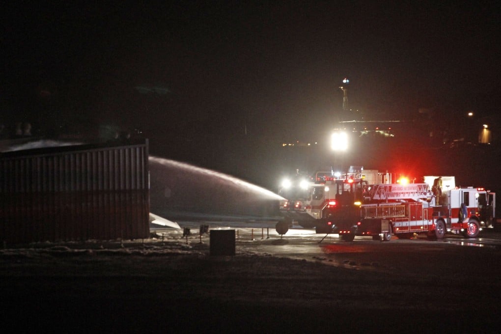 Firefighters and officials stand at the scene where a twin-jet Cessna Citation crashed into a hangar and caught fire after landing at the Santa Monica Airport. Photo: Reuters