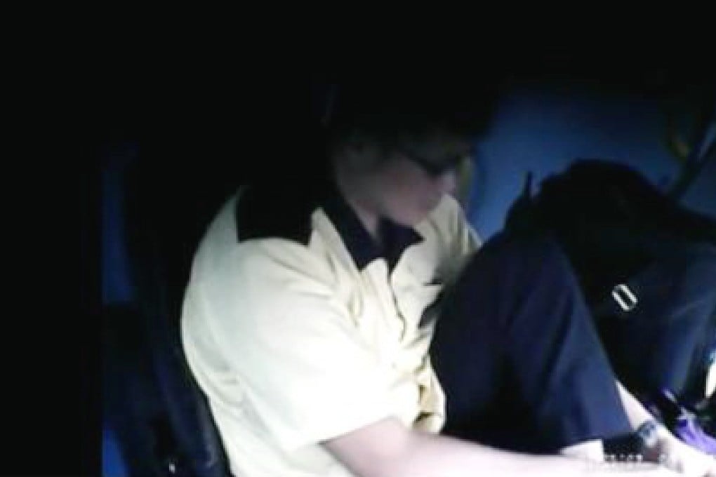 A still from the clip shows the driver clipping his toenails