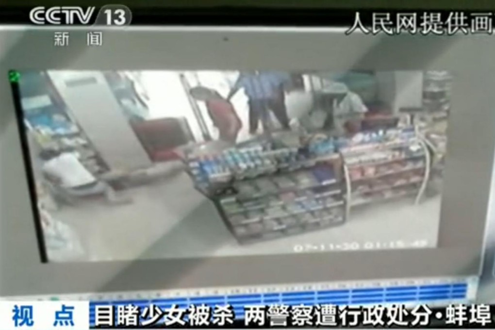 Two policemen watch as a woman is stabbed in Bengbu, Anhui, in August. Screenshot via Sina Weibo