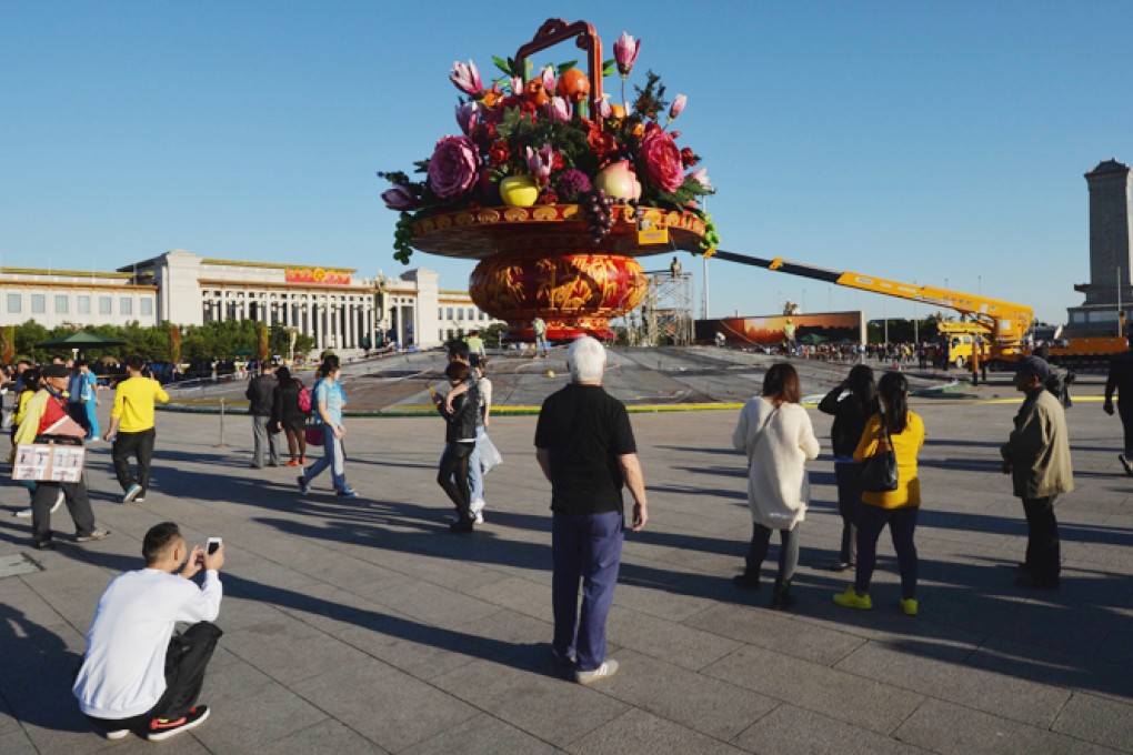 Workers install a giant vase containing fruit and flowers as part of the upcoming Chinese National Day celebrations at Tiananmen Square in Beijing. Photo: AFP