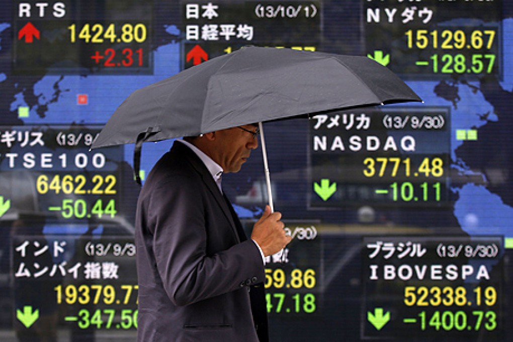 A man walks past a stock quotation board in Tokyo on Tuesday  as investors wait to see how much of the US government will shut down after the US Congress missed a deadline to agree on a new budget. Photo: Reuters