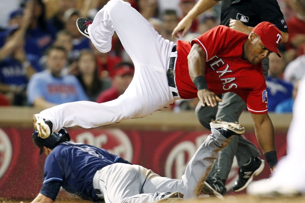 Tampa Bay Rays' Sam Fuld (left) steals third base as Texas Rangers' Adrian Beltre dives for a wild throw by Tanner Scheppers during their tiebreaker game on Monday. Photo: AP