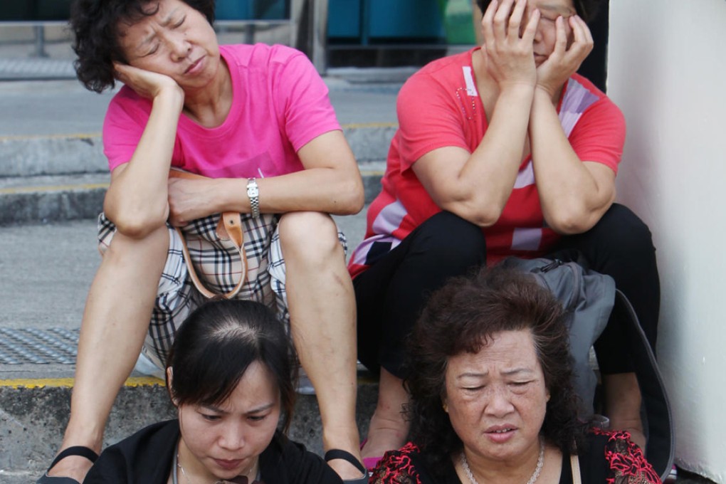 Weary mainland tourists take a break in Golden Bauhinia Square, Wan Chai. Photo: Nora Tam