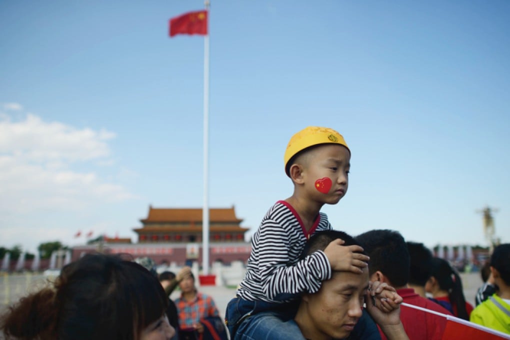 Visitors stand before the national flag on Tiananmen Square in Beijing. Photo: AFP