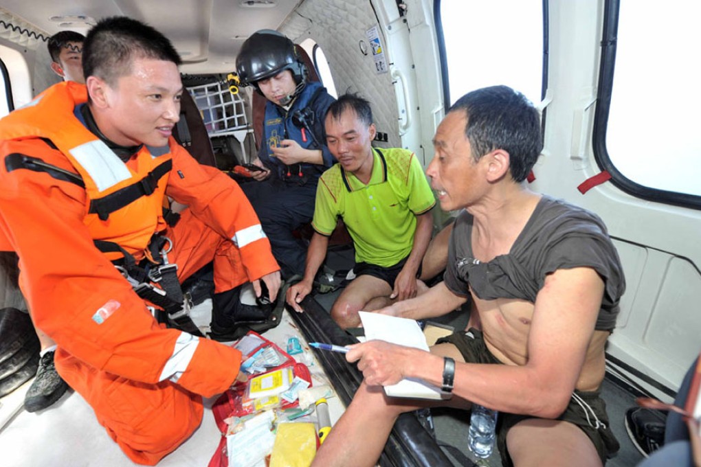 Rescuers talk with two fishermen after they were saved from the sinking ship in Hainan. Photo: Xinhua