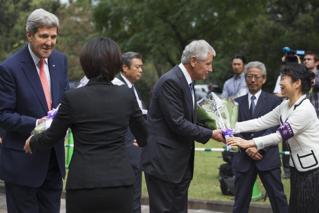 Kerry (left) and Hagel receive flowers at the cemetery. Photo: Reuters