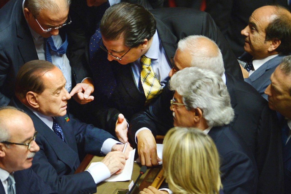 Silvio Berlusconi (second left) in an angry exchange with members of his People of Freedom party before the confidence vote. Photo: AFP
