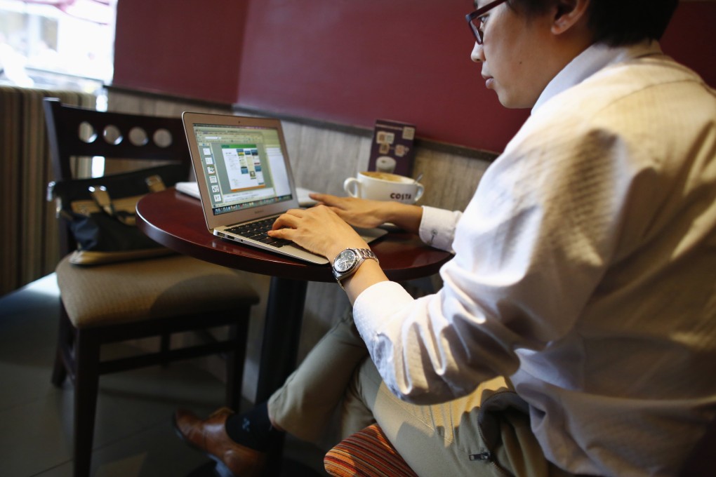 A man works on his computer inside a coffee shop in downtown Shanghai. Government employees monitor public opinion on social media. Photo: Reuters