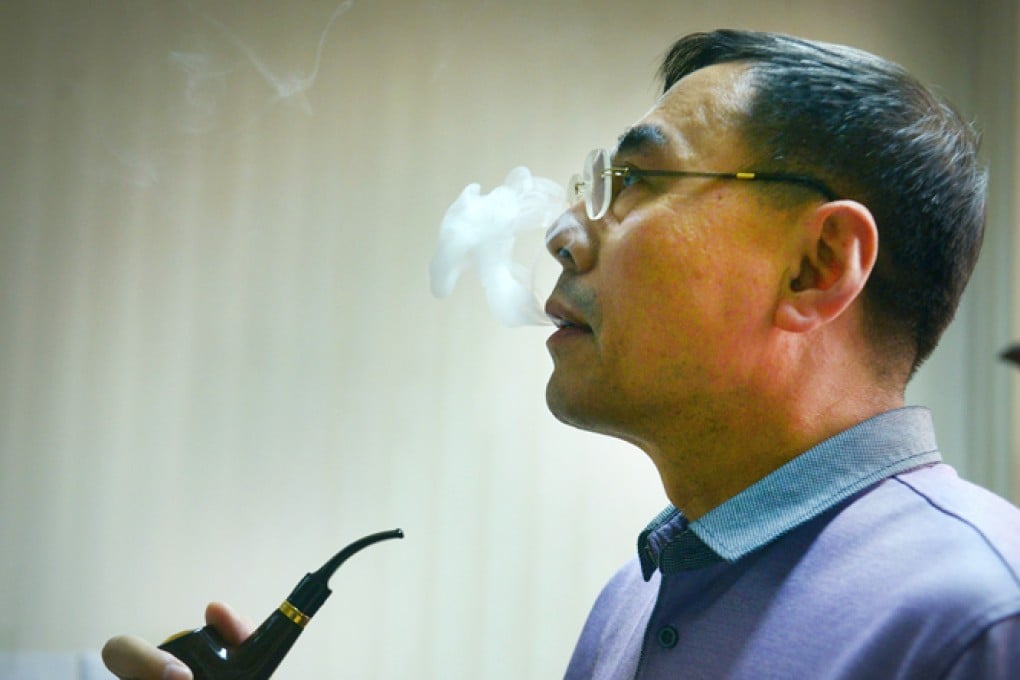 Hon Lik smokes an electronic tobacco pipe. Photo: AFP