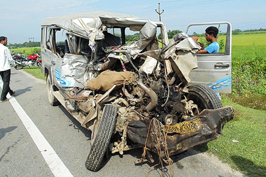 Indian residents gather beside the wreckage of a vehicle at an accident site in the village of Doholapara in Barpeta district some 120km west of Guwahati on Thursday. Photo: AFP