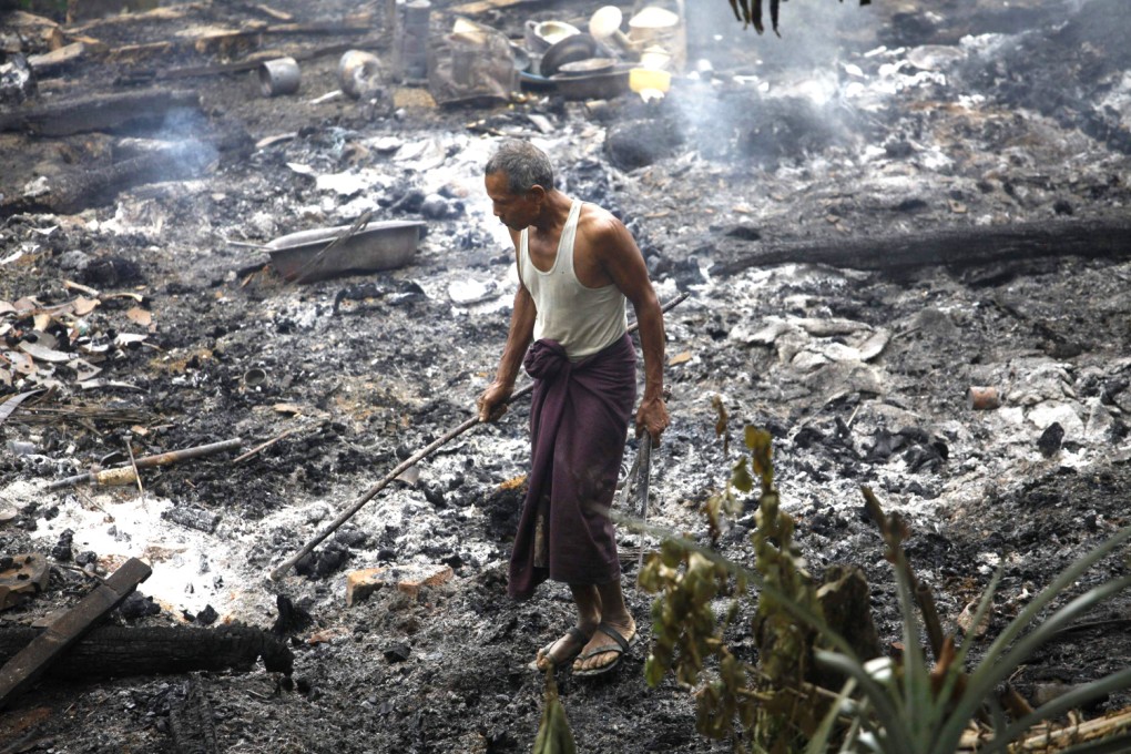 A Muslim man searches for his belongings left behind of his burnt home at Thapyuchai village in Rakhine state. Photo: Reuters