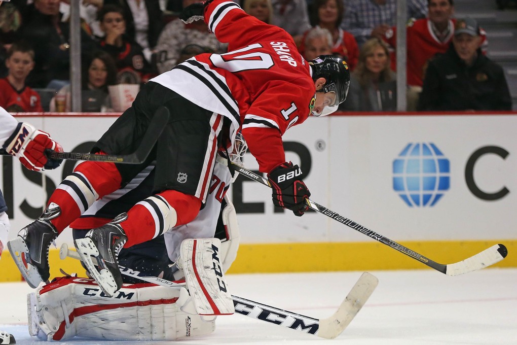 Chicago Blackhawk Patrick Sharp, who falls over Braden Holtby of the Washington Capitals, is called for goaltender interference. Photo: AFP