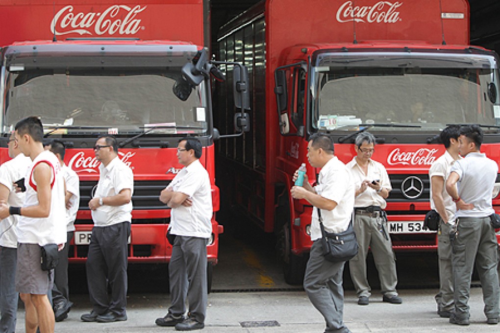 Striking workers walk the picket line at the Swire Beverages plant in Sha Tin on Thursday. Photo: David Wong