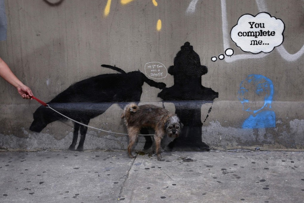 Life imitates art as a dog urinates on a creation by the British graffiti artist Banksy. Photo: Reuters