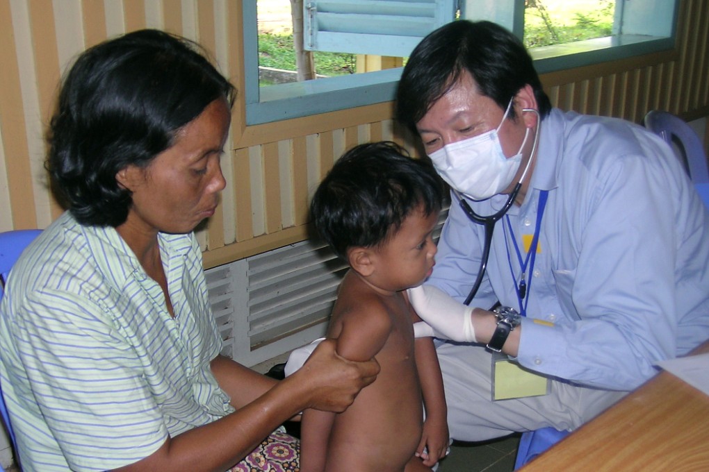 Dr Vincent Leung gives a free medical consultation to a child and mother in Kampong Thom, Cambodia. He and fellow doctors go there every year. Photo: Vincent Leung