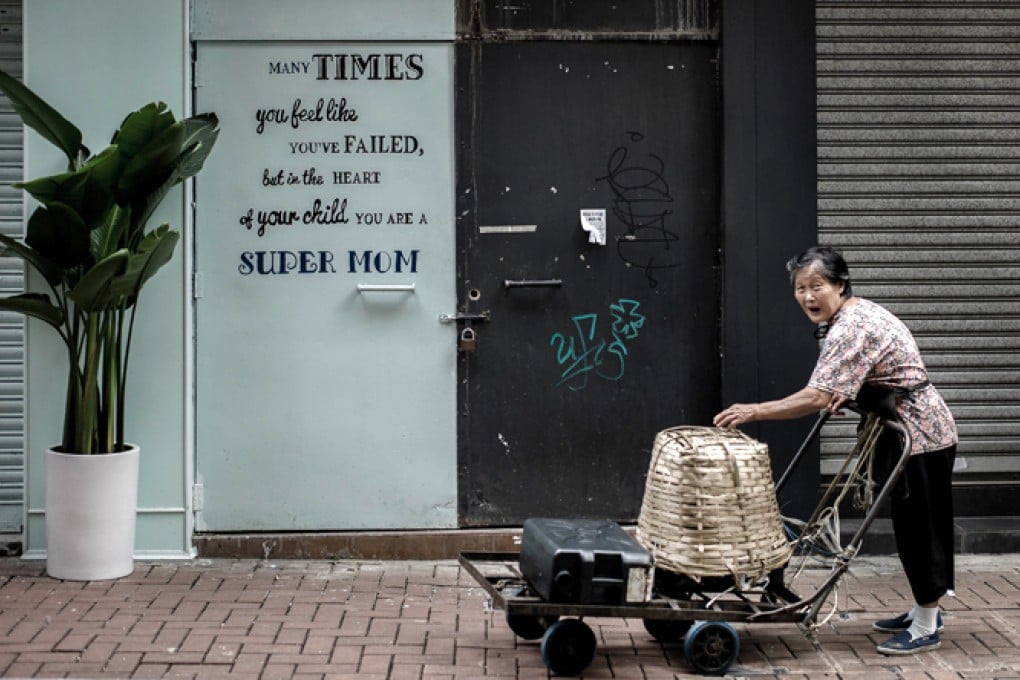 An elderly woman pushes a handcart in Hong Kong Photo: AFP