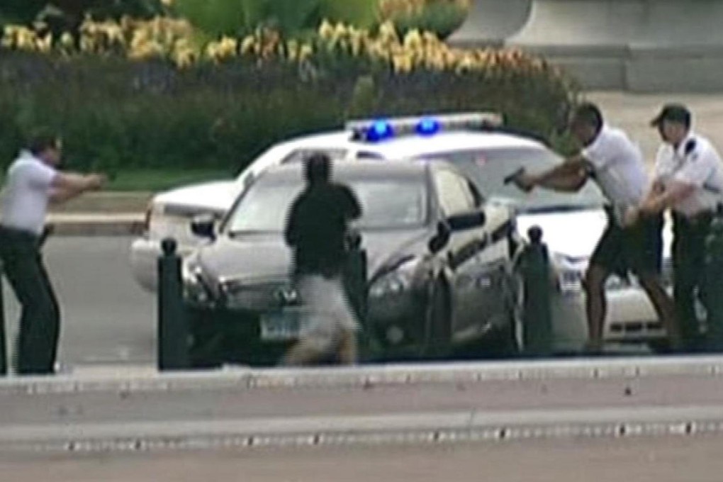 Police surround the car and aim their guns at the driver at the corner of Pennsylvania Avenue and 1st Street in a frame-grab from Alhurra TV footage - the car was driven away and a chase ensued. Photo: Reuters