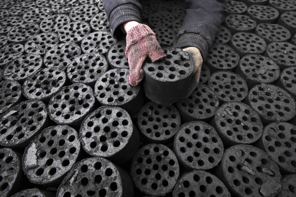 A worker moves coal briquettes onto a pedicab at a coal distribution business in Huaibei, central China's Anhui province. Photo: AP