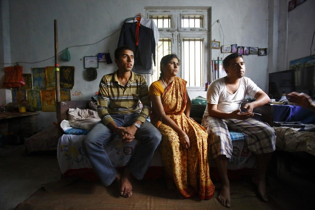 Raju Prasad Lamichhane (left), his mother and brother sit in their half-finished house. Photo: Reuters