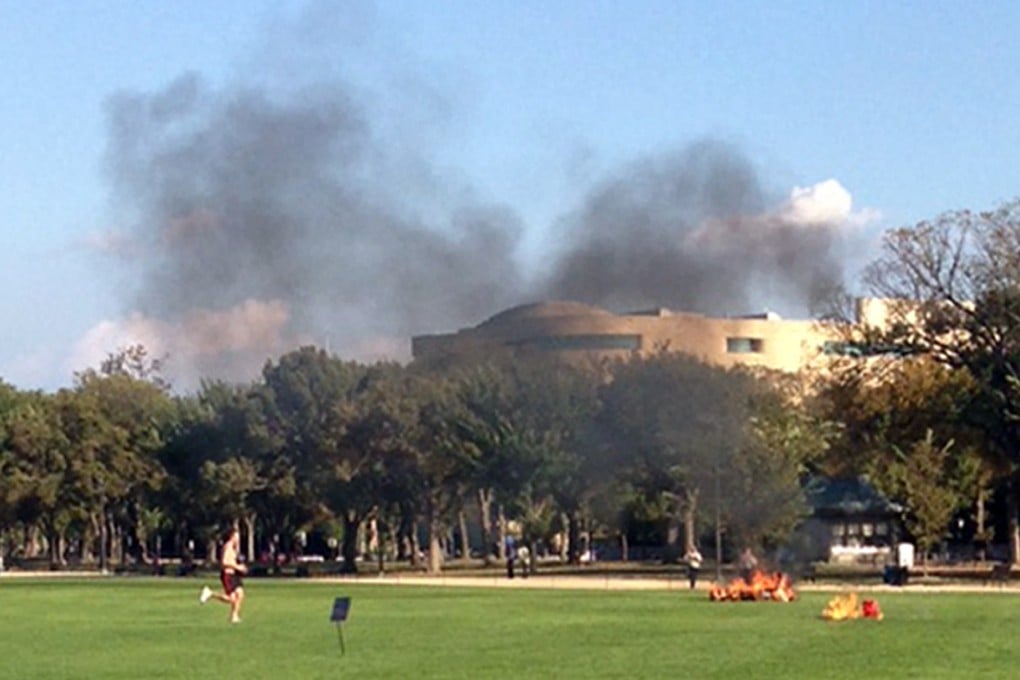 People run to a man who set himself on fire on the National Mall in Washington on Friday. Photo: AP