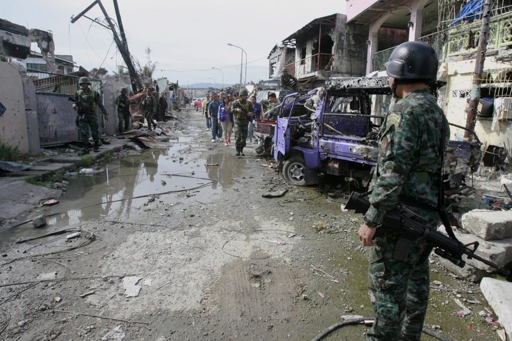 Filipino soldiers stand guard during clearing operation in the war ravage district of Zamboanga City, southern Philippines, on 30 September 2013. Photo: EPA