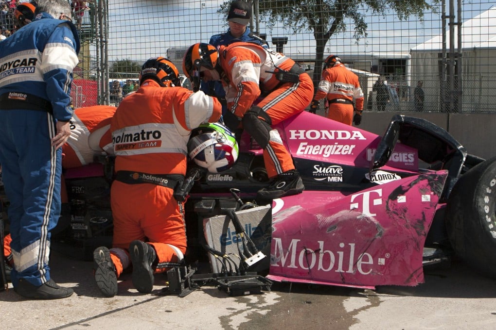 Safety team members work to remove Dario Franchitti, of Scotland, from his car after the crash. Photo: AP