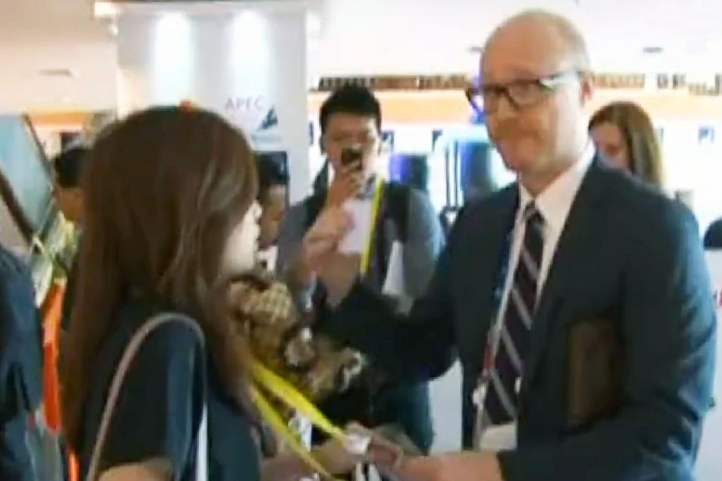 An Apec staff member takes a reporter's pass. Photo: Now TV