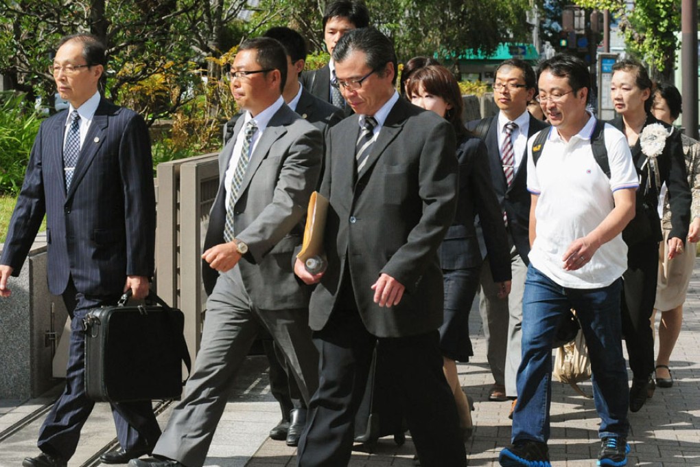 A group of plaintiffs arrive at the Kyoto District Court in Kyoto for a verdict over a case they filed against a group of anti-Korean activists. Photo: AP