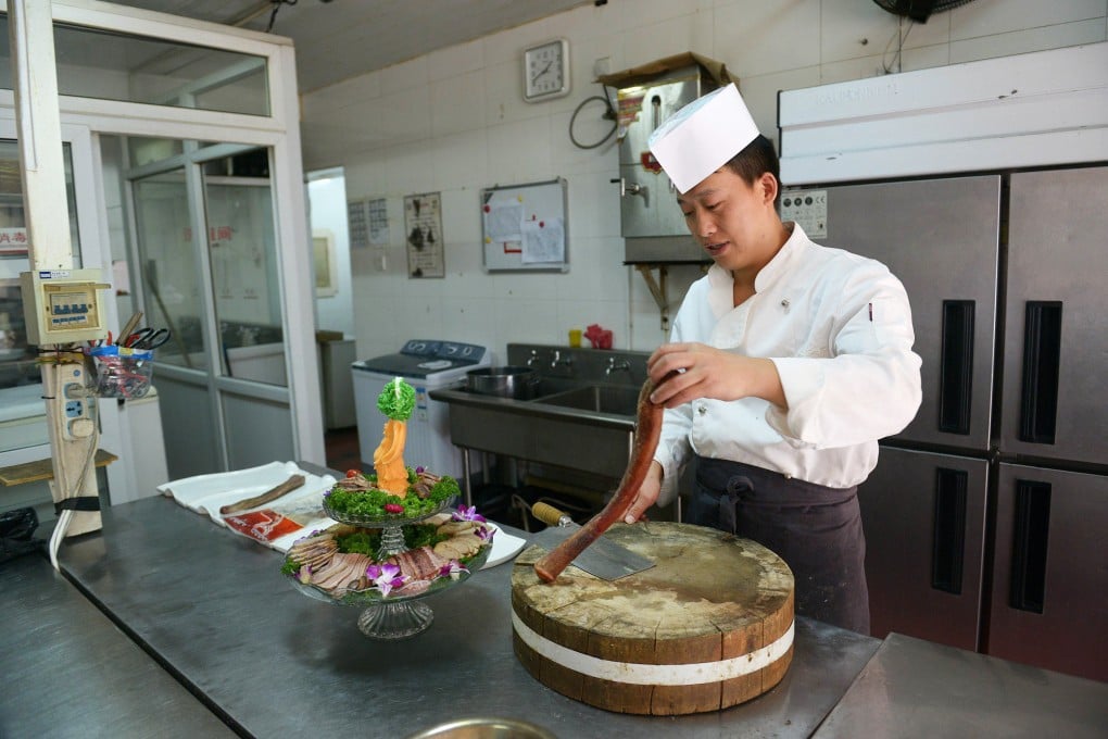 A cook prepares a dish of animal penis in the kitchen of a hotpot restaurant in Beijing. Photo: AFP