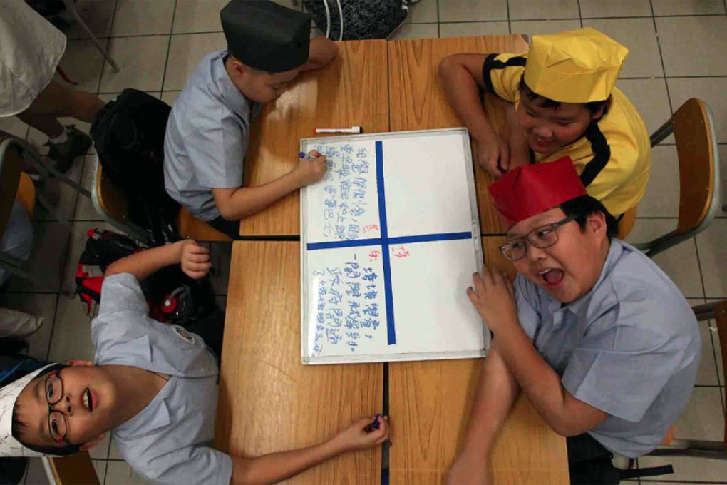 Pupils at Fresh Fish Traders’ School wear different coloured hats to discuss national education from different perspectives. Photo: Felix Wong