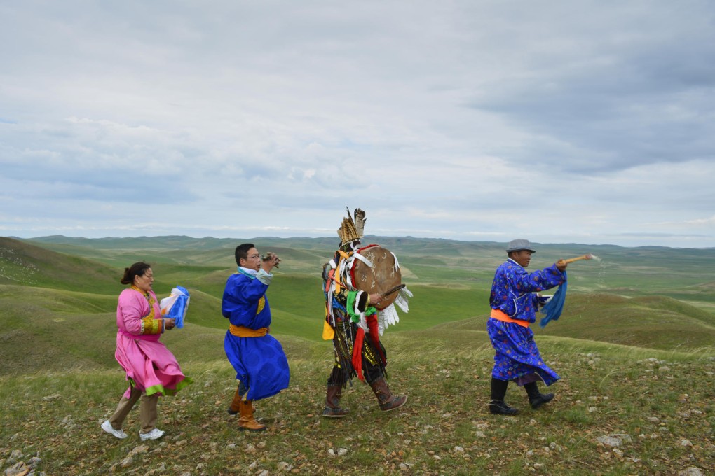 Mongolian shaman Erdemt (second from right), his wife, Oyuunbileg (far left), their son, Bao Lidao (second from left), and cousin Baater take part in an annual ritual on the grasslands near Xiwuqi.