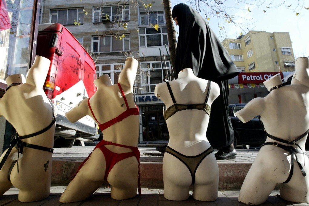 In a sign of the times in Turkey, where women's dress is a controversial issue, a veiled Muslim walks past a warehouse displaying underwear in downtown Istanbul. Photo: AFP
