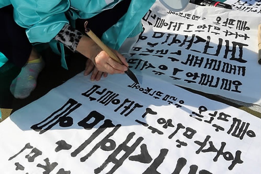 A South Korean woman participates in a calligraphy contest to observe Hangul Day. Photo: Screenshot via Yonhap News.