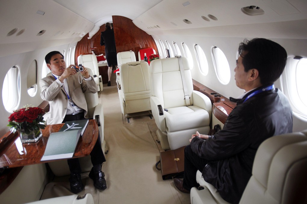 A visitor has his photograph taken in an American International Group Inc' s Falcon 7X aircraft. Photo: Reuters