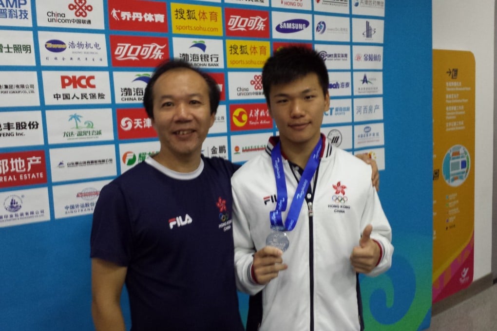Xie Zhen shows off his silver medal alongside his proud father, Xie Feng. Photo: SCMP Pictures