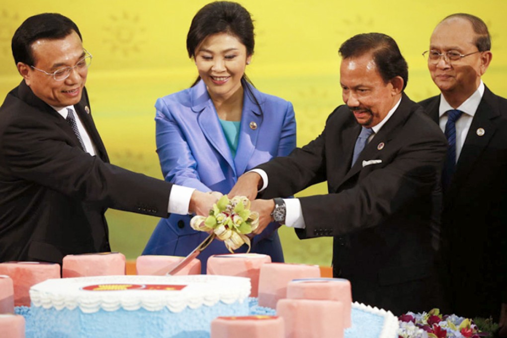 Li Keqiang (left) cuts a cake with Thai PM Yingluck Shinawatra and Brunei’s Sultan Hassanal Bolkiah. Myanmar’s Thein Sein looks on. Photo: AP