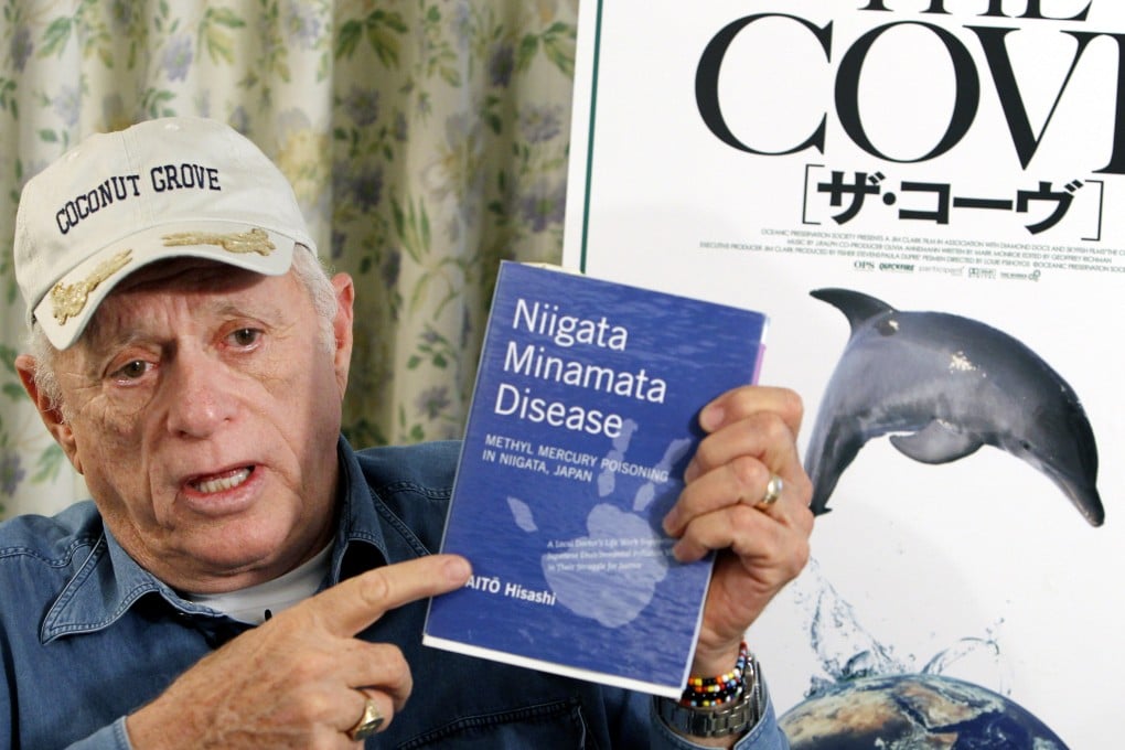 Ric O'Barry, whose efforts to save dolphins is documented in the Oscar-winning film "The Cove," speaks while showing a book about mercury poisoning. Photo: AP