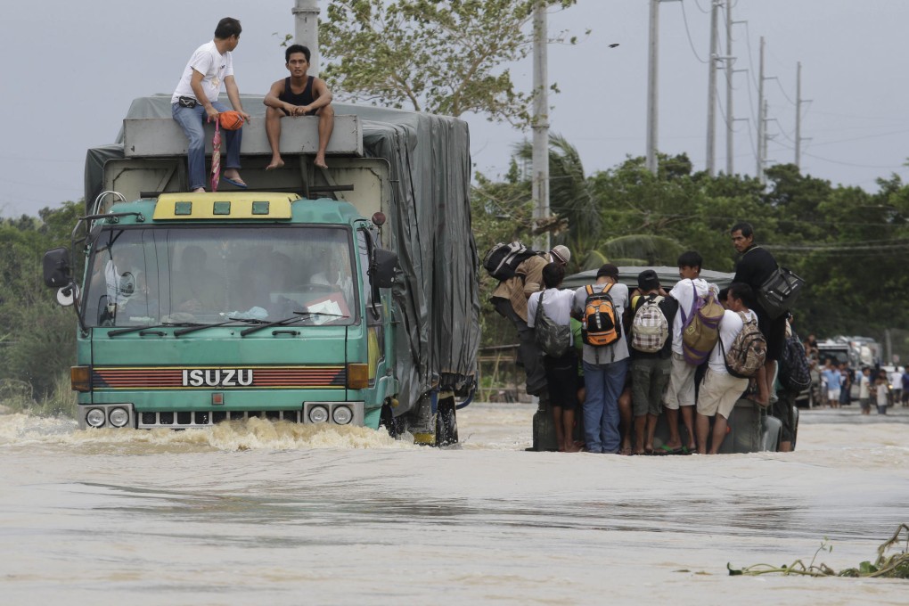Motorists brave the raging floodwaters brought about by Typhoon Nari to get across a highway in San Ildefonso north of Manila yesterday. Photo: AP