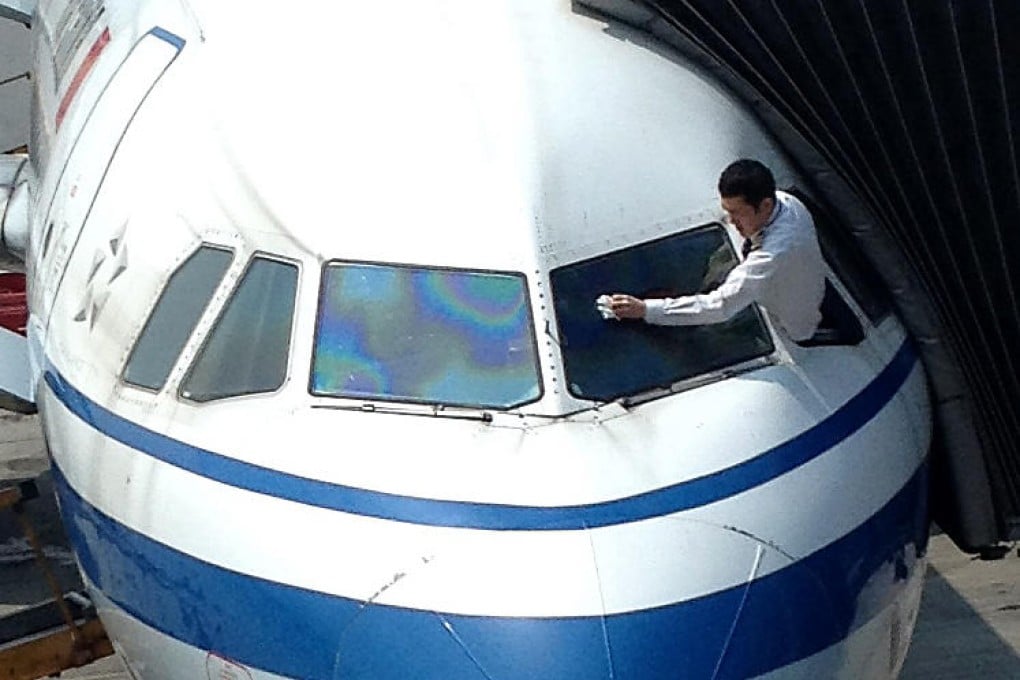 The Air China pilot wipes the windscreen. Photo: Red Door News