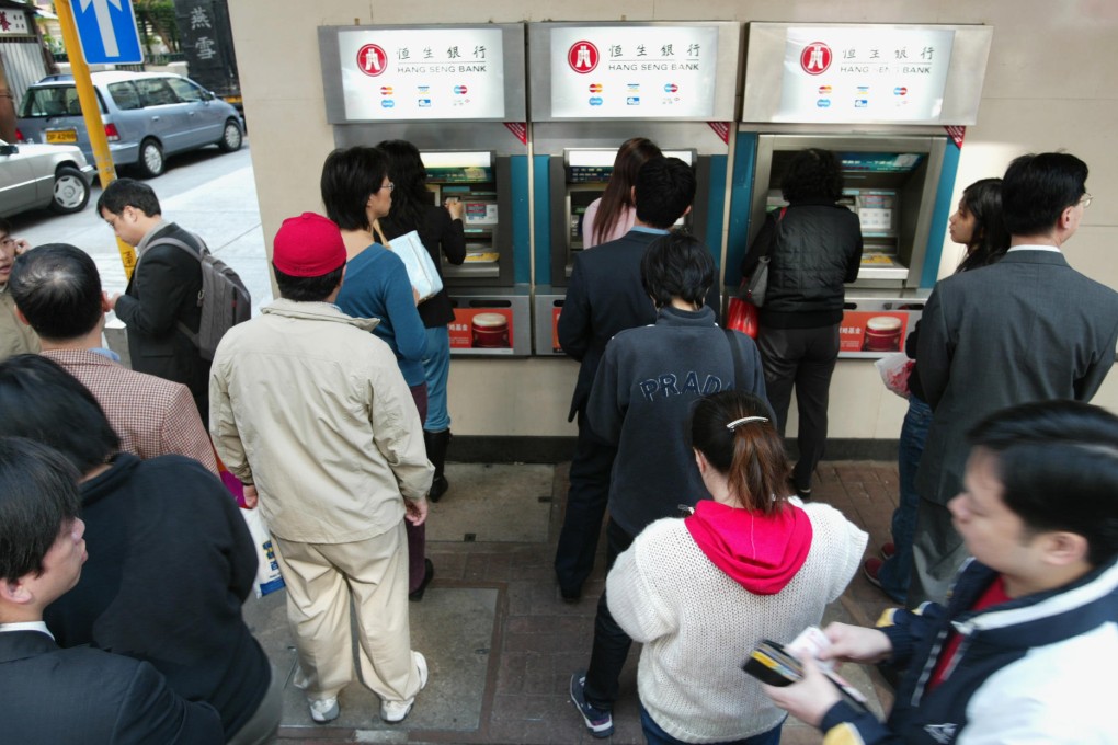 Users line up at ATMs in Wan Chai. Jetco is teaming up with other banks to start a smartphone payment system. Photo: SCMP