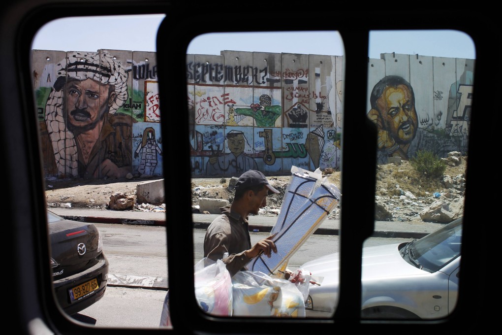 A mural depicts the late Palestinian leader Yasser Arafat at the Qalandiya checkpoint near the West Bank city of Ramallah. Photo: Reuters