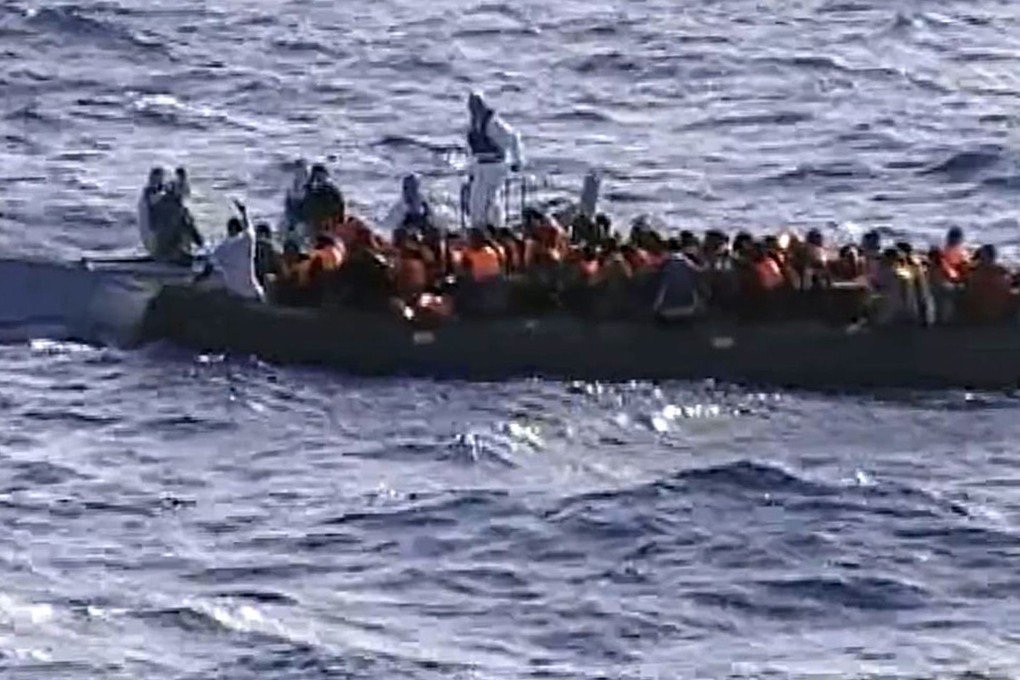 Immigrants aboard a raft while being rescued from the sea by Italian Navy off Lampedusa. Photo: AFP/Italian Navy