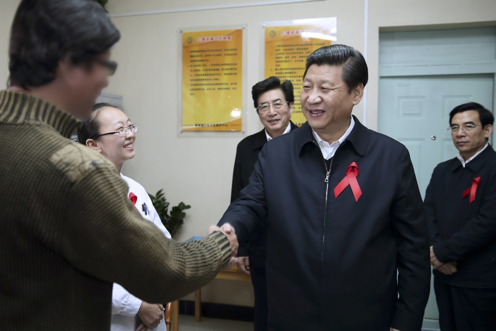 File photo taken in November 2012 shows Xi Jinping shaking hands with an HIV-positive man in Beijing. Photo: Xinhua