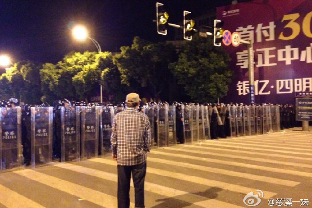 A solitary Yuyao resident confronts riot police on Tuesday evening. Screenshot via Sina Weibo
