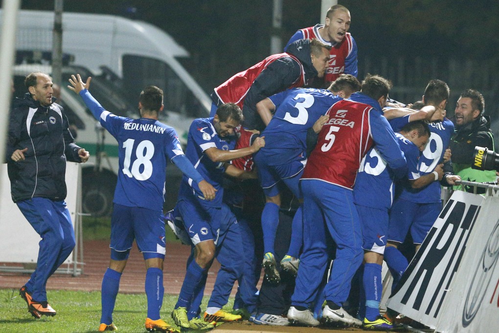 Bosnia players jump for joy after reaching the World Cup finals. Photo: AP