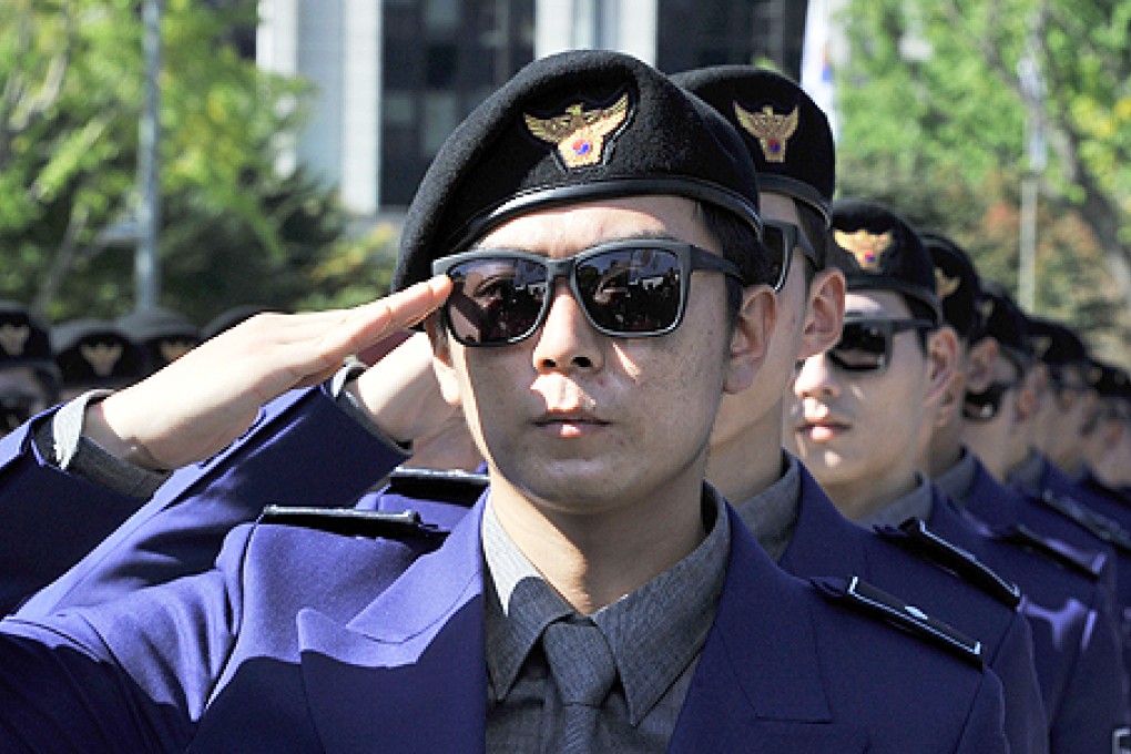 South Korean 'tourist police' officers salute during their inauguration ceremony at Gwanghwamun square in Seoul on Wednesday. Photo: AFP