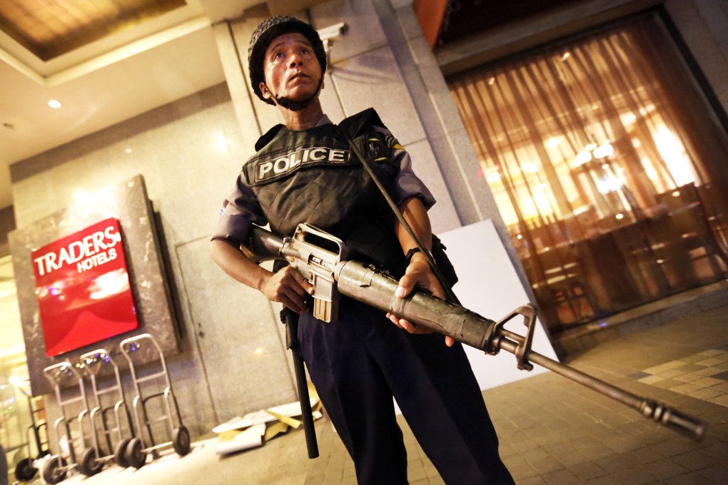 A Myanmar policeman stands guard in front of the Traders Hotel after an explosion in Yangon. Photo: Xinhua