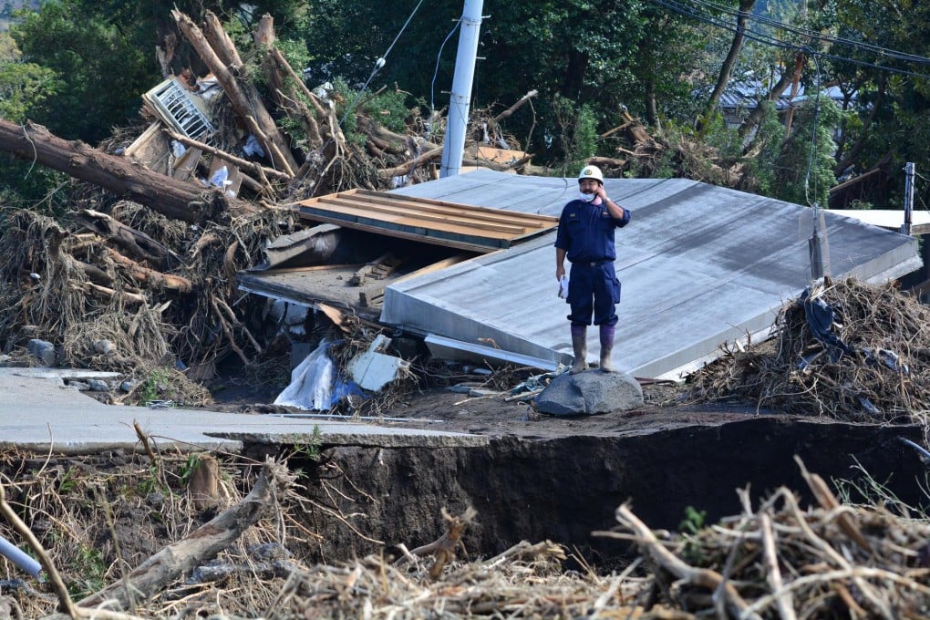 A policeman stands on a collapsed road. Photo: AFP