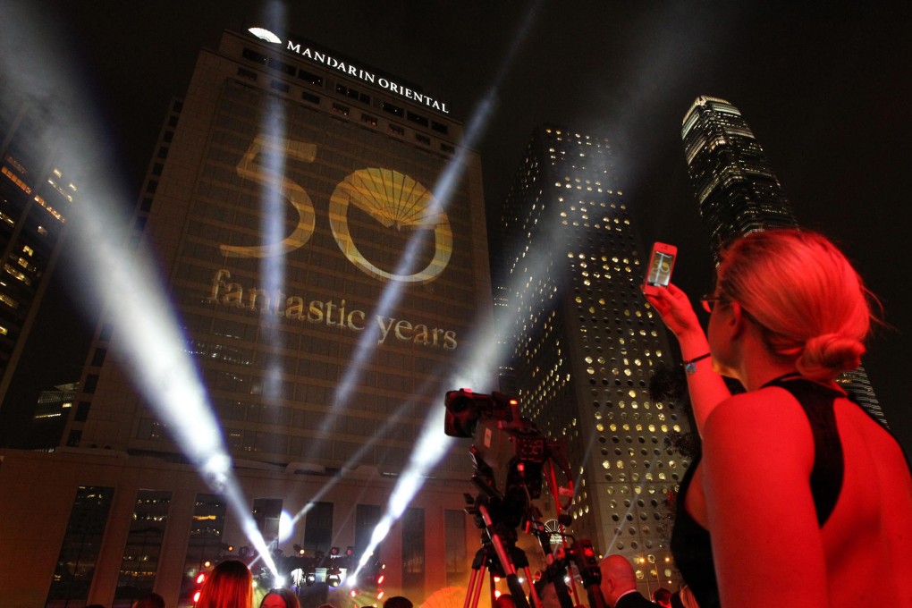 A guest snaps a picture of the 3-D projection beamed on the façade of the Mandarin Oriental flagship hotel last night. Photo: Nora Tam