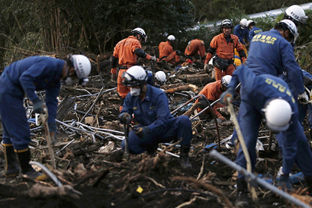 Rescue workers search for victims at a site damaged by a landslide caused by Typhoon Wipha in Izu Oshima island, south of Tokyo on Thursday. Photo: Reuters